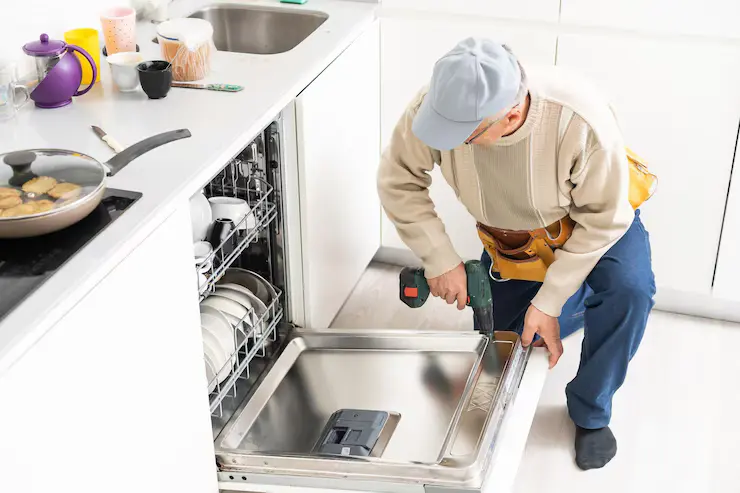 Rørlegger reparerer oppvaskmaskin på kjøkkenet